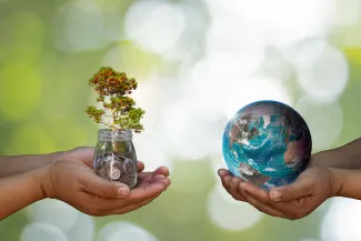 Natural Capital Accounting: picture of hands holding coins and hands holding the planet Earth